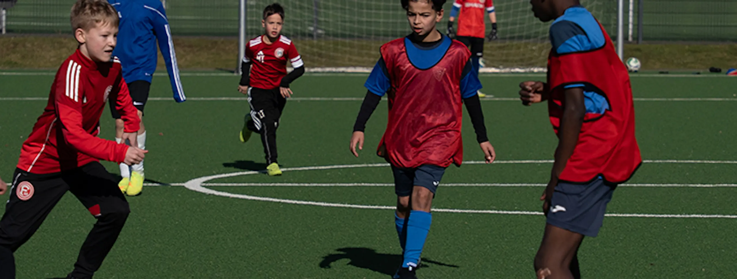 Group of kids playing competitive soccer drill on training field - PWR PLY Soccer Academy