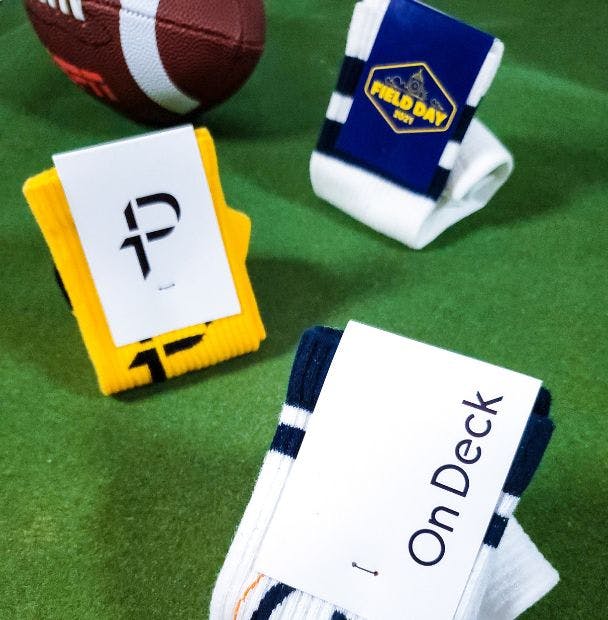 Custom Football socks shown on a green field with a football in the background