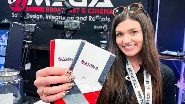 Omega Broadcasting holding up the custom socks that they used as trade show giveaways