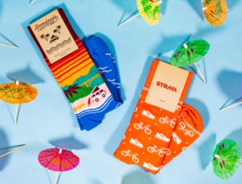 Hawaiian, tropical, and vacation themed socks for Boondoggle and Strava with drink umbrellas and blue background