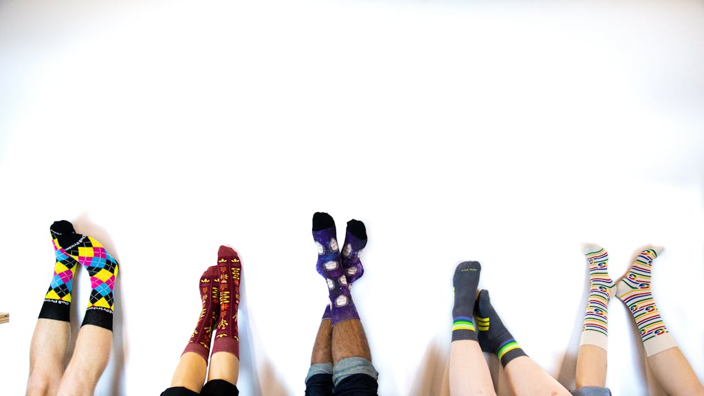 custom socks with logo upside down in air against wall