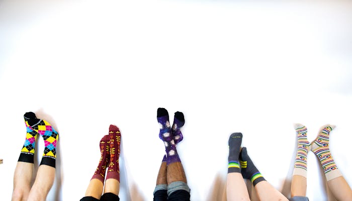custom socks with logo upside down in air against wall