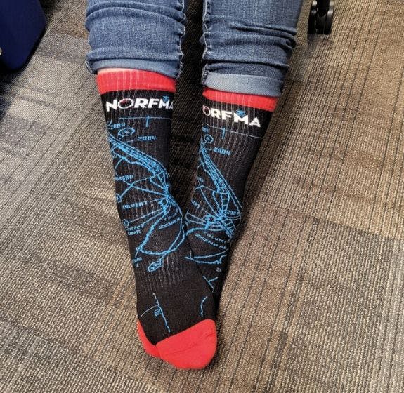 Custom athletic socks for NORFMA featuring their logo and a design that outlines the floodplains of the pacific northwest