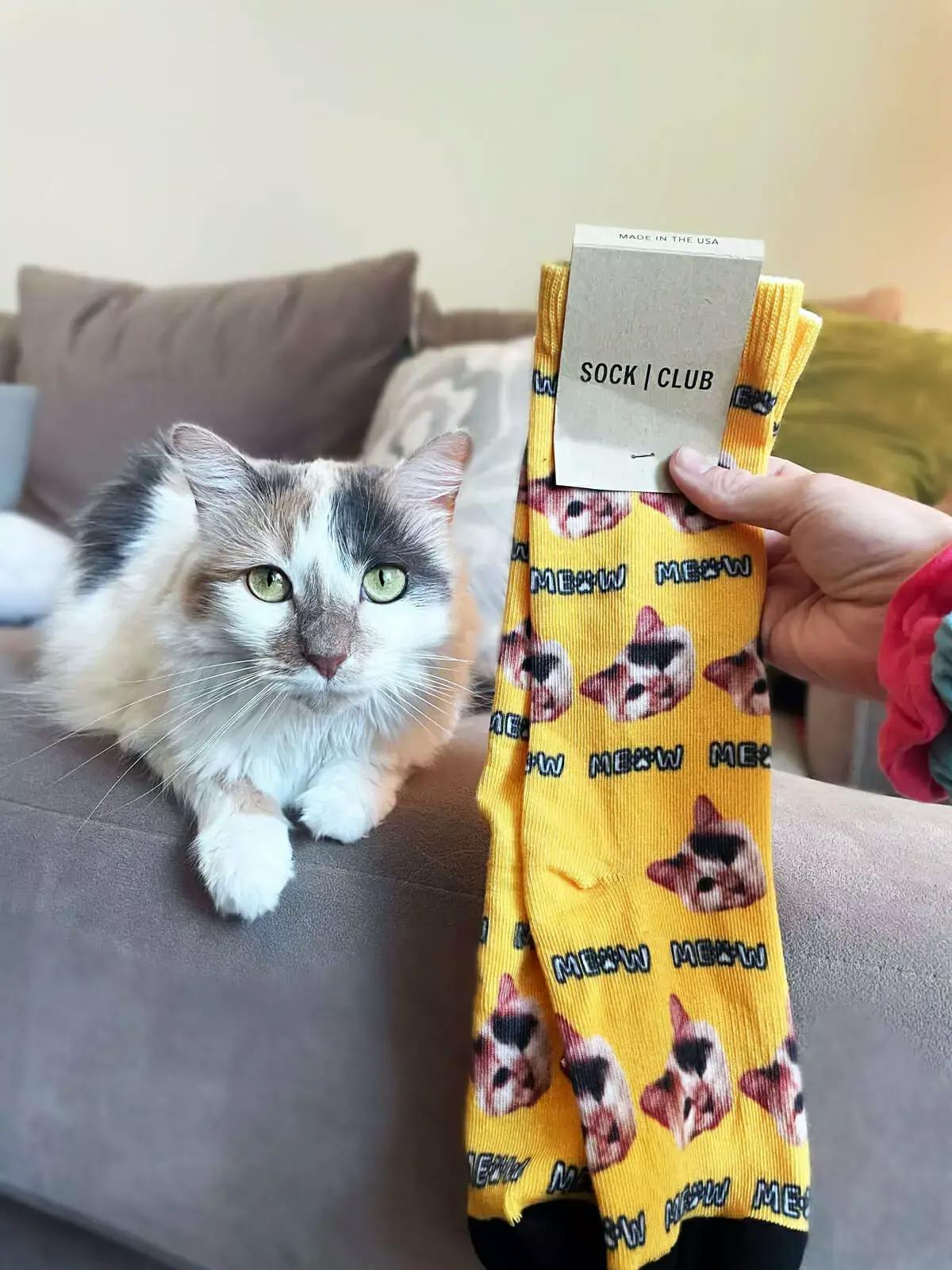 A custom pair of yellow face socks with a cat face on them.