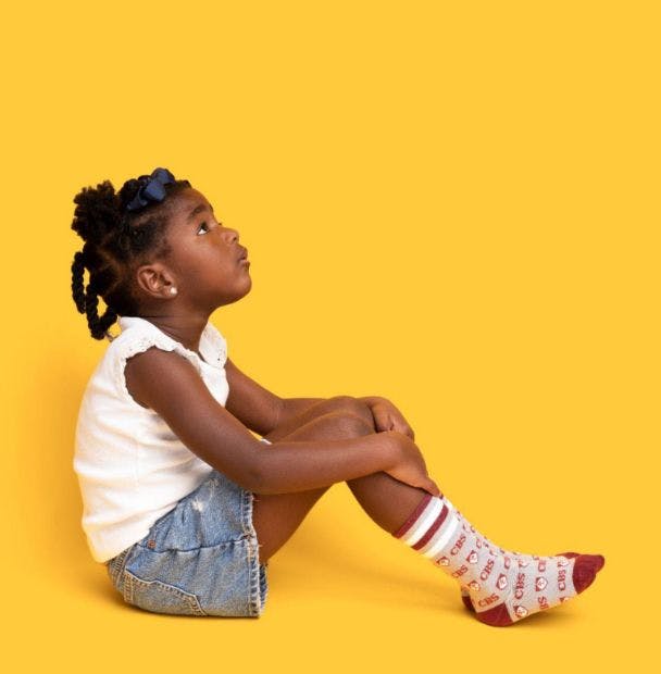 Custom Branded Socks for the CHS School on a young girl sitting down on a yellow background