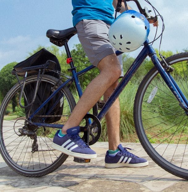 Branded ankle socks with logo worn by a man riding a bike outside on a trail
