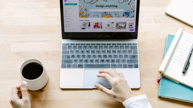 A creator making a design on Canva at her desk to post and sell on an online merch store