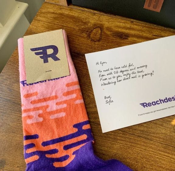 Custom branded socks from Reachdesk with a branded postcard with a handwritten note to a client