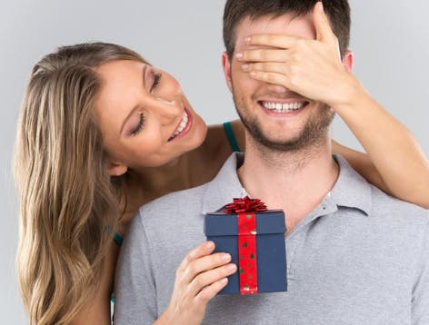 Woman surprising man with a small gift