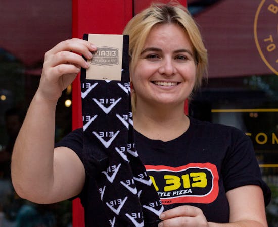 woman holding black custom socks with logo of via313