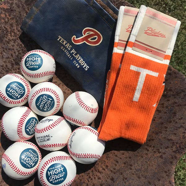 Orange Texas Playboys knee high baseball socks next to pille of baseballs 