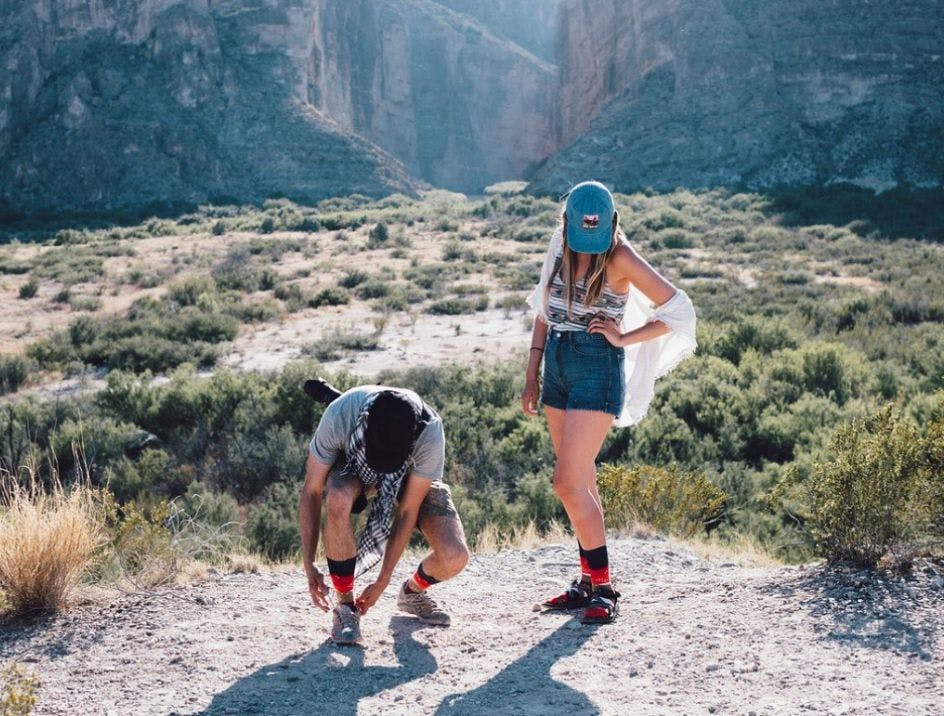 Two people on a desert hike wearing wool socks for hiking