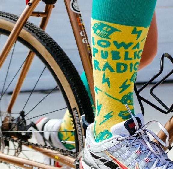 Custom socks for donor gifts for fundraising for Iowa Public Radio being worn by a person riding a bike
