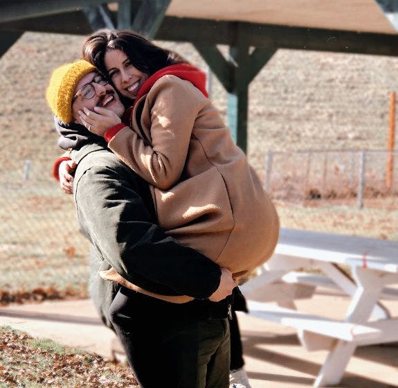 Kellen and Kevin hugging and embracing after they got engaged in a park