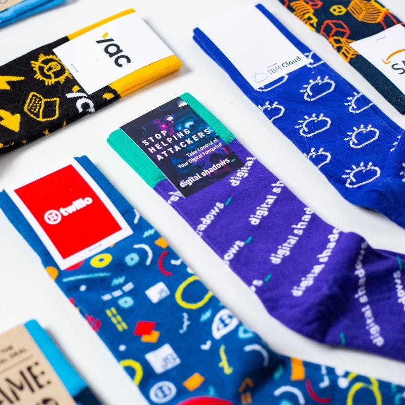 Custom Logo socks on a white background with branded socks for Twilio, Digital Shadows, IBM Cloud, and YAC