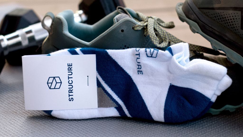 Custom athletic ankle sock on a gym floor with gym shoes and weights in the background