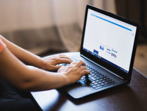 woman typing on computer to buy custom socks online