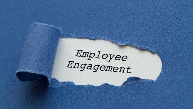 Blue paper being torn to reveal white paper underneath that says employee engagement