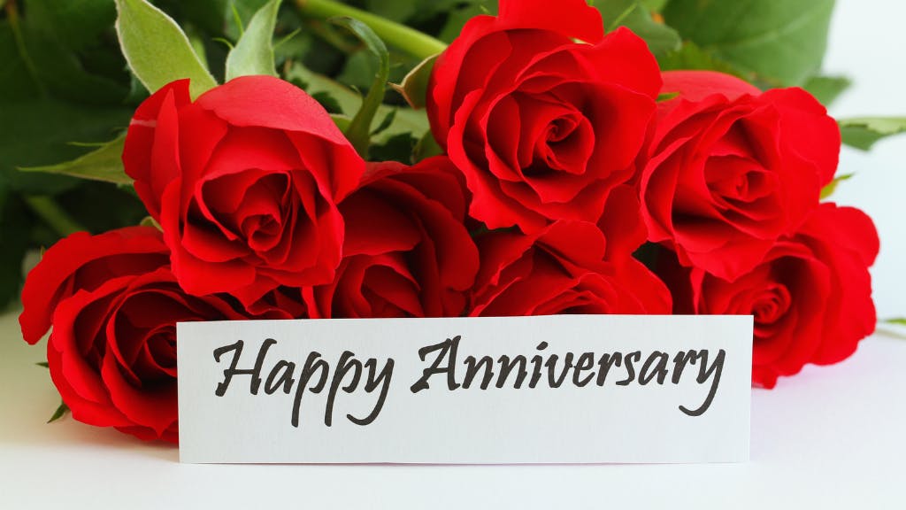 Red rose bouquet with Happy Anniversary sign.