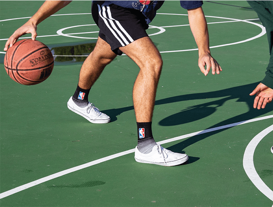Two people playing basketball wearing black athletic socks