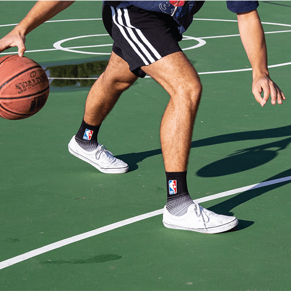 Two people playing basketball wearing black athletic socks
