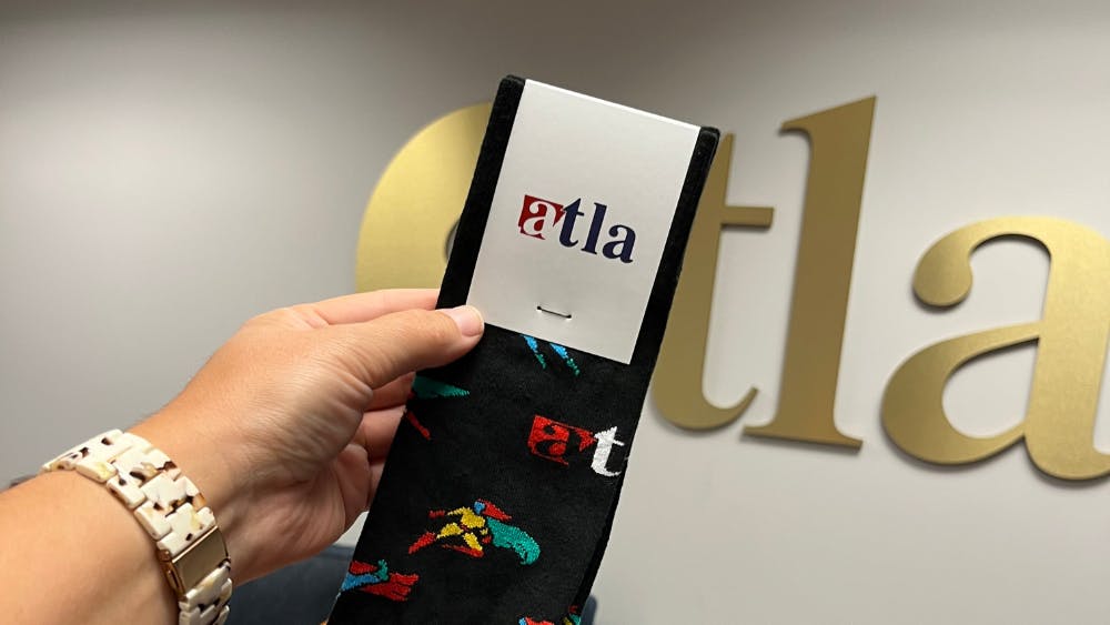 employee holding pair of custom ATLA socks