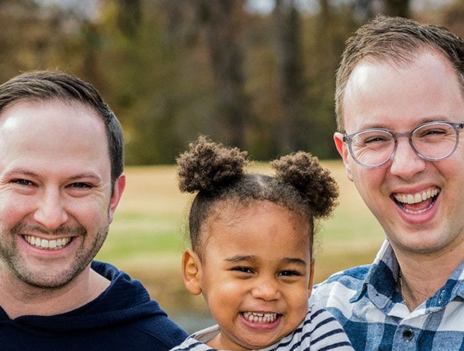 Two parents and their adopted child that benefitted from the adoptive parent support at Capital One