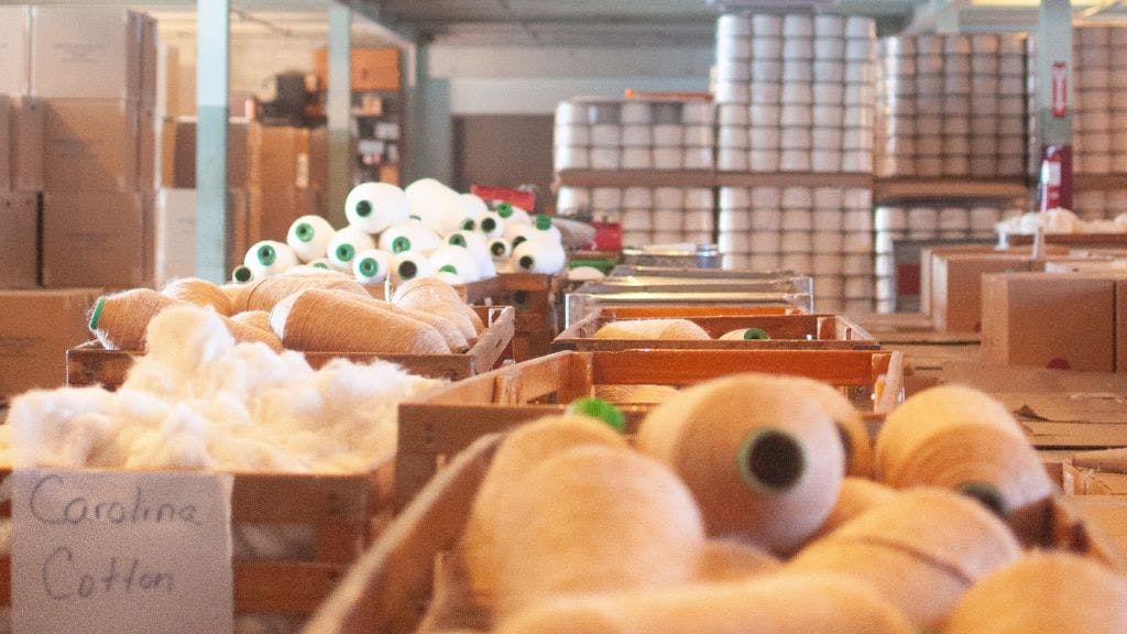 Sock Club's cotton spinning facility showing cotton in various stages of processing, from raw to yarn