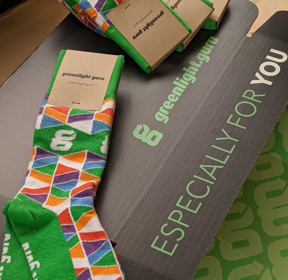 Green and multi-color patterned custom trade show giveaway socks for Greenlight Guru