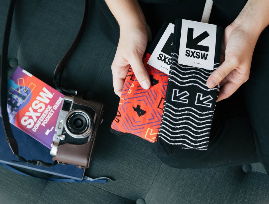 Person holding SXSW branded socks for trade show giveaway 
