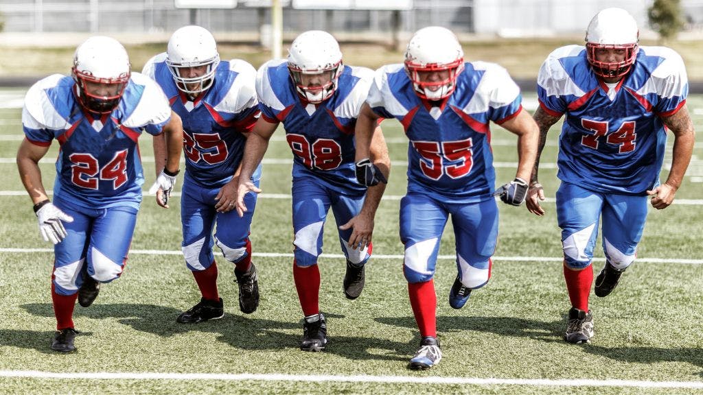 Football team running down the field showing their football socks