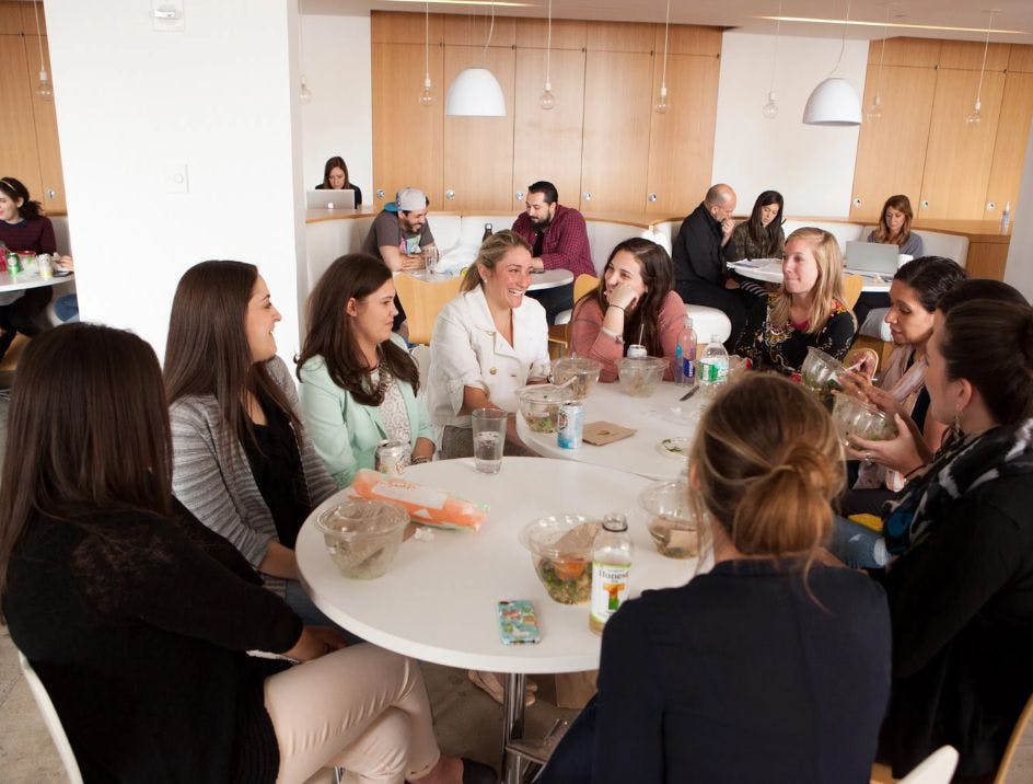 Positive company culture example, The Knot Worldwide, staff enjoying a lunch together, laughing in a company cafeteria
