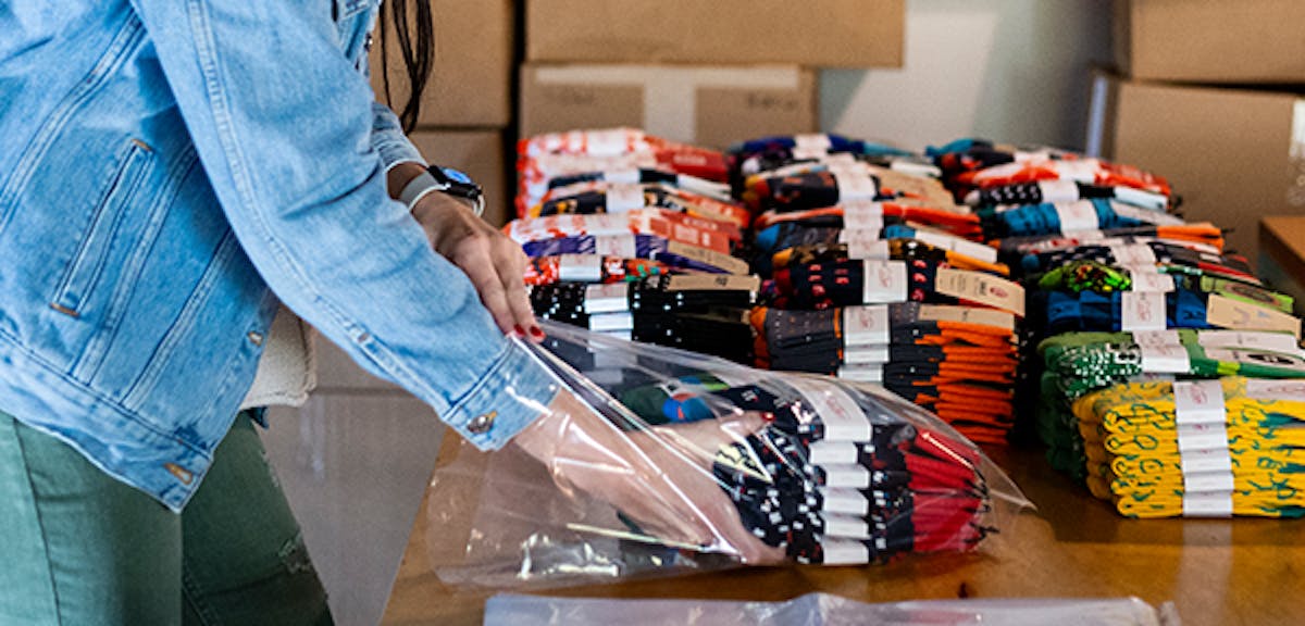 Person packing custom socks for event giveaway