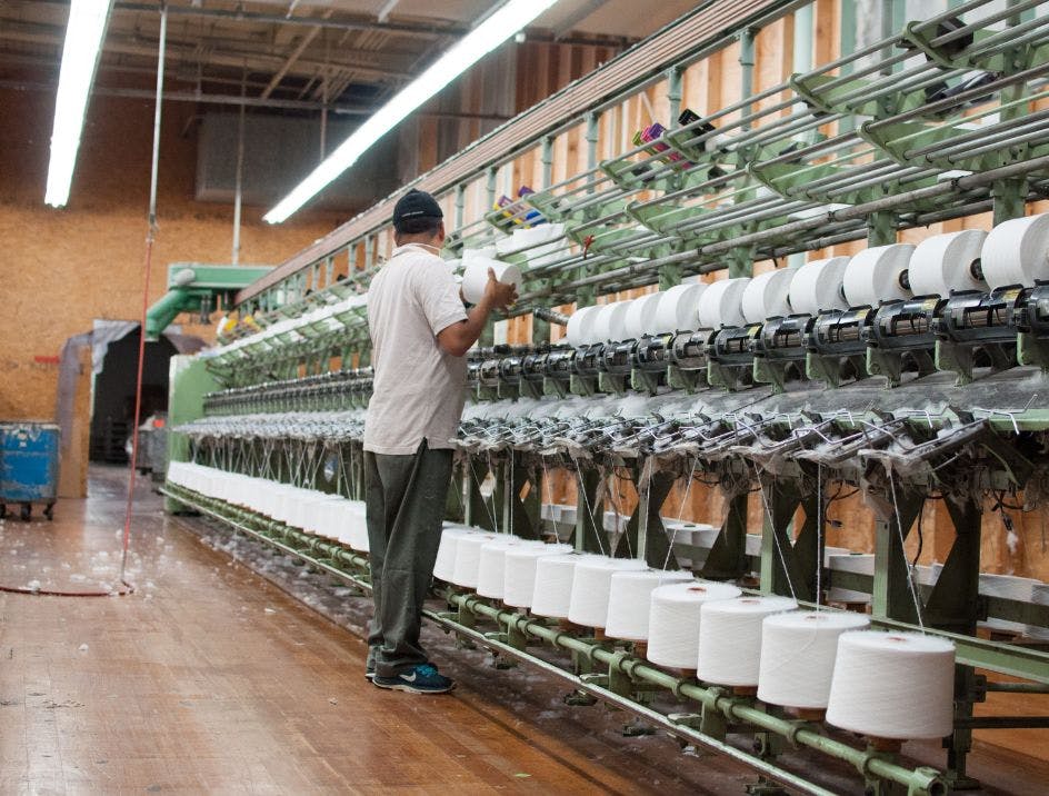 US factory worker spinning the final cotton yarn into its thinnest length