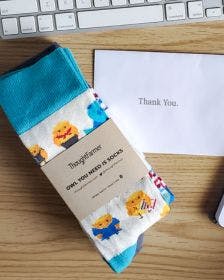 Employee Appreciation custom branded socks on an employee's desk with a thank you note