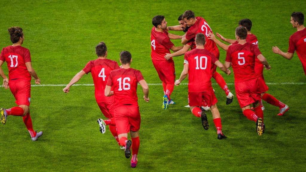 Adult Soccer Team running on the field in matching team uniforms