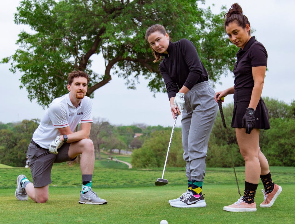 Group of people playing golf and wearing crew length socks