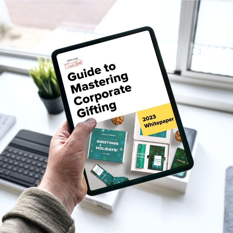 Sock Club's "Guide to Mastering Corporate Gifting" displayed on an iPad in a modern office setting