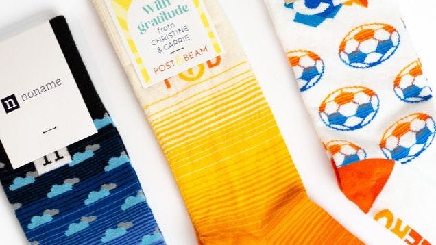 Custom socks with gradients knit into them showing a blue gradient, orange gradient, and blue to orange gradient in a soccer ball pattern
