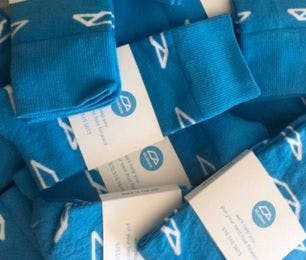 Branded socks for Bluetent with the message "we'll help you put your best foot forward" on the sock packaging.