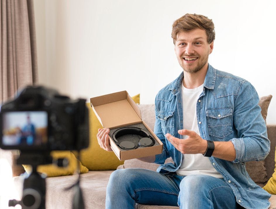 Male influencer filming a video in his living room to promote a set of headphones