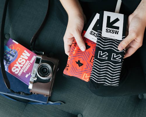 custom socks with logo of SXSW in black and orange for events with camera 