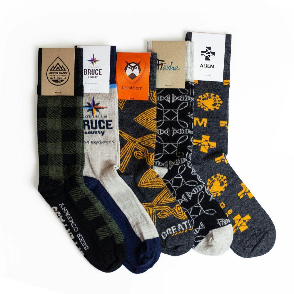Model wearing branded black and grey knitted Wool Socks with Custom Sock Packaging for Fisher brand with Repeating Logo Design