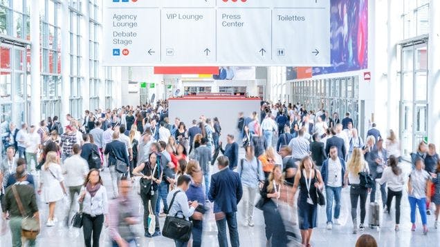 Crowded exhibit hall with booth traffic