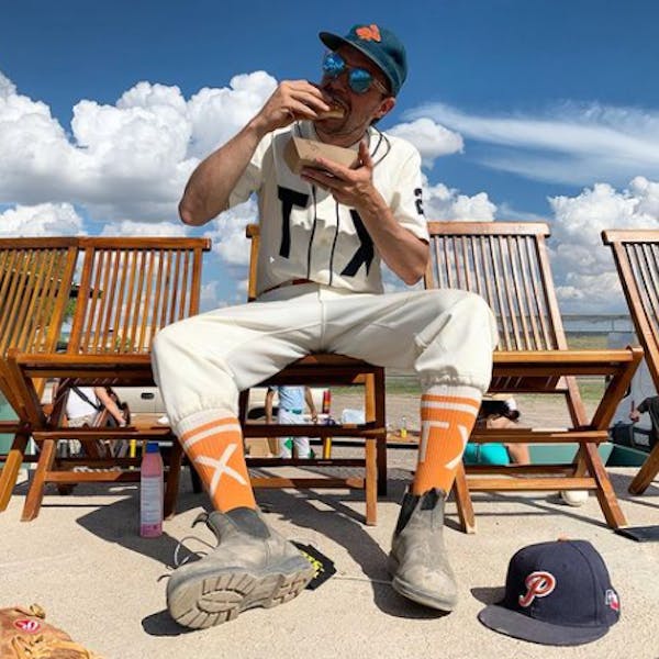 custom softball socks worn by player eating hotdog