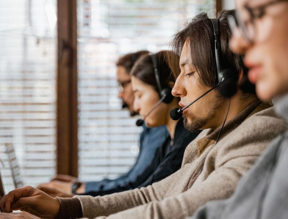 Call operators shown speaking to customers in a remote call center
