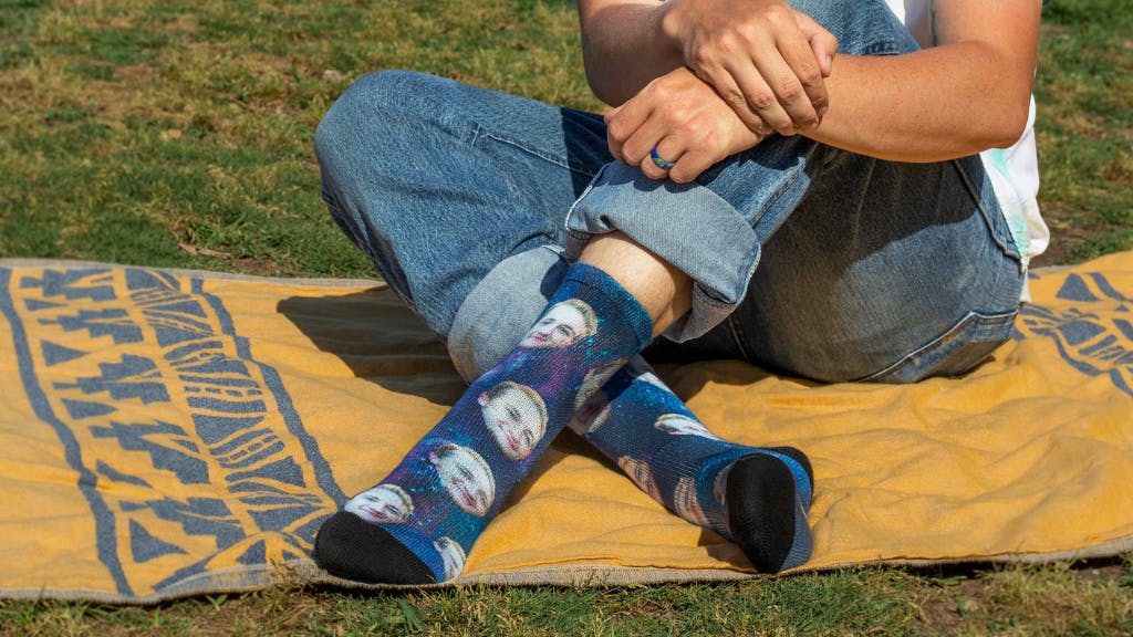 Face socks for him on a park lawn and picnic blanket.