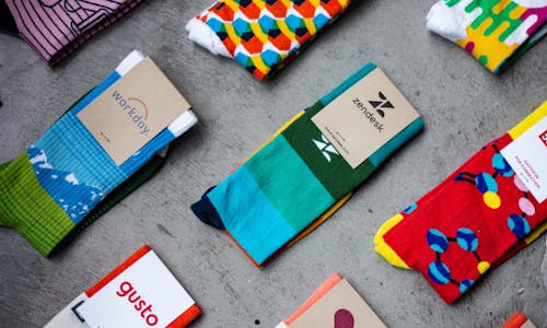 custom socks with logo over concrete desk with zendesk socks gusto socks and workday socks