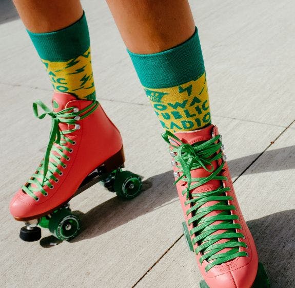 Socks with logo for fundraising for Iowa Public Radio being worn by a donor wearing roller skates