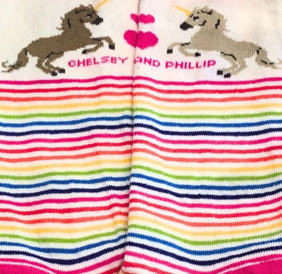 personalized wedding socks with rainbow stripes featuring unicorns and the bride and groom's names at the top